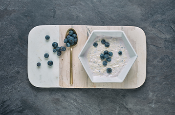 A fresh Food Fit meal containing blueberry cheesecake in a white hexagonal bowl.