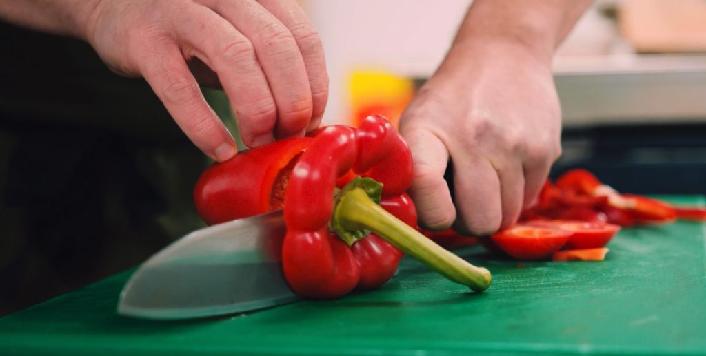 Chopping a sweet pepper with a knife shows how healthy our food is.