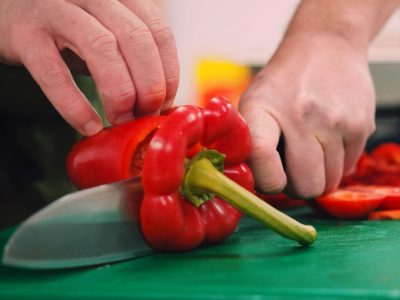 Chopping a sweet pepper with a knife shows how healthy our food is.