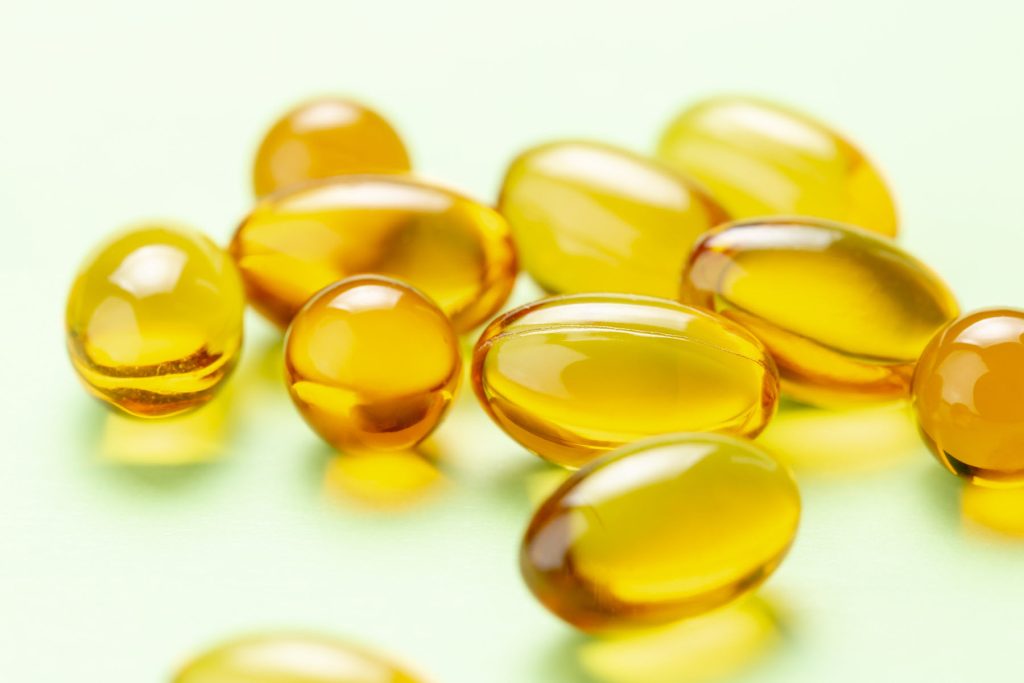 Yellow vitamin D capsules showing there's evidence they can reduce the risk of influenza and COVID-19 infections and deaths.