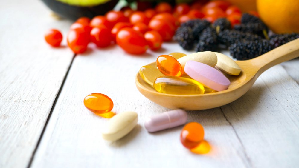 A wooden spoon surrounded by multivitamin tablets imply supplements can be useful.