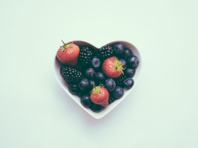 A heart-shaped bowl full of fruit indicates the importance of heart health.