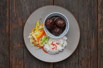A healthy, vegan Food Fit meal containing kung pork, rice, and salad on a grey plate.