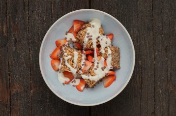 A deliciously prepared Food Fit breakfast meal containing vegan chocolate and strawberry bake bar in a light blue bowl.