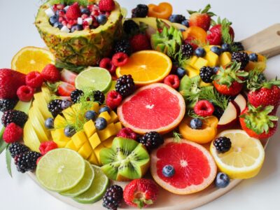 A wooden plate filled with a large variety of fruit that help with muscle growth